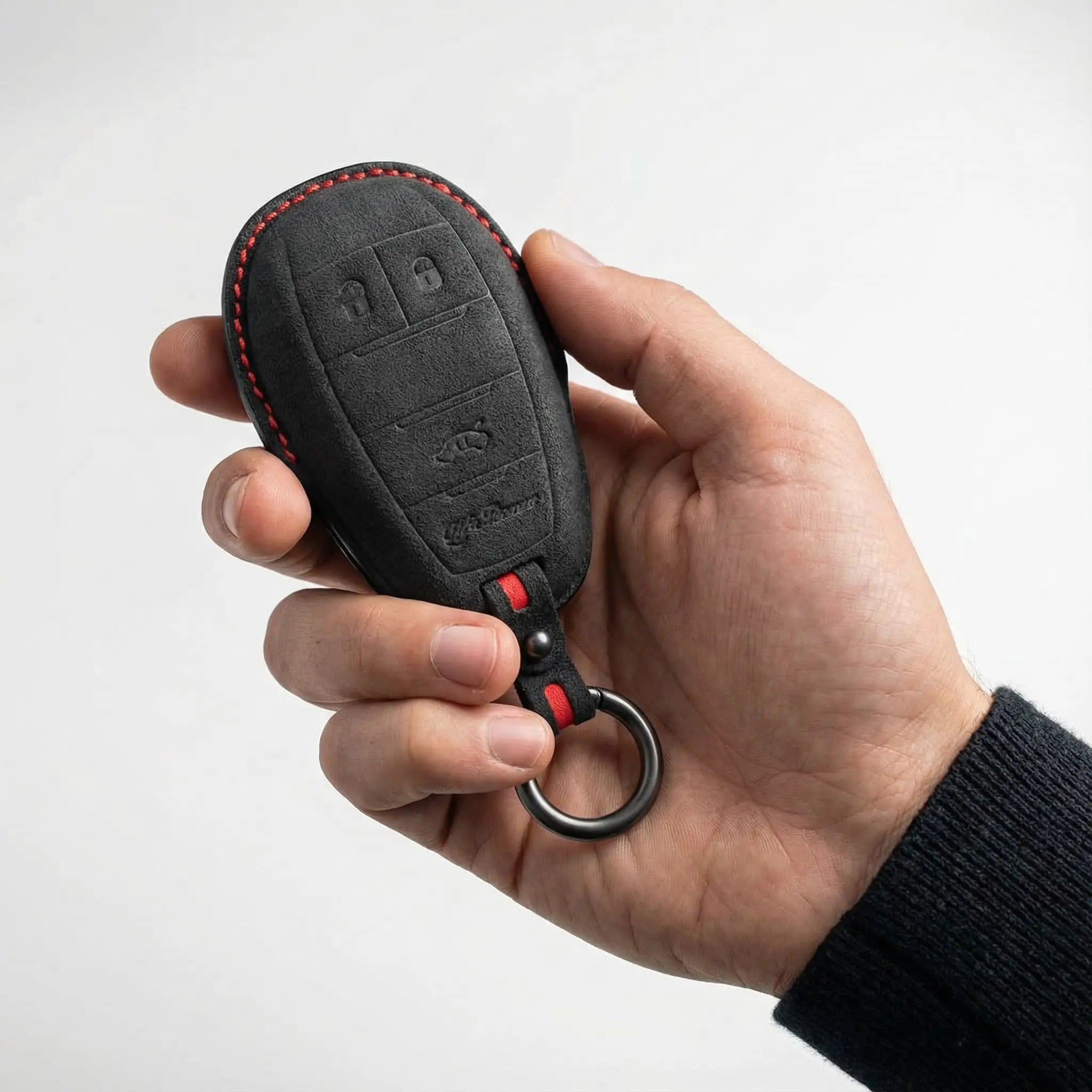 Hand holding Alfa Romeo key fob with Alcantara cover dark grey red stitching - Giulietta 147 159
