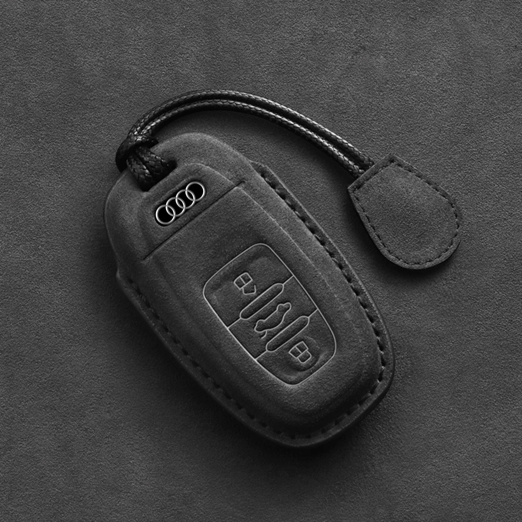 Audi key fob with Alcantara cover held in hand, showing ergonomic design and luxury suede finish.