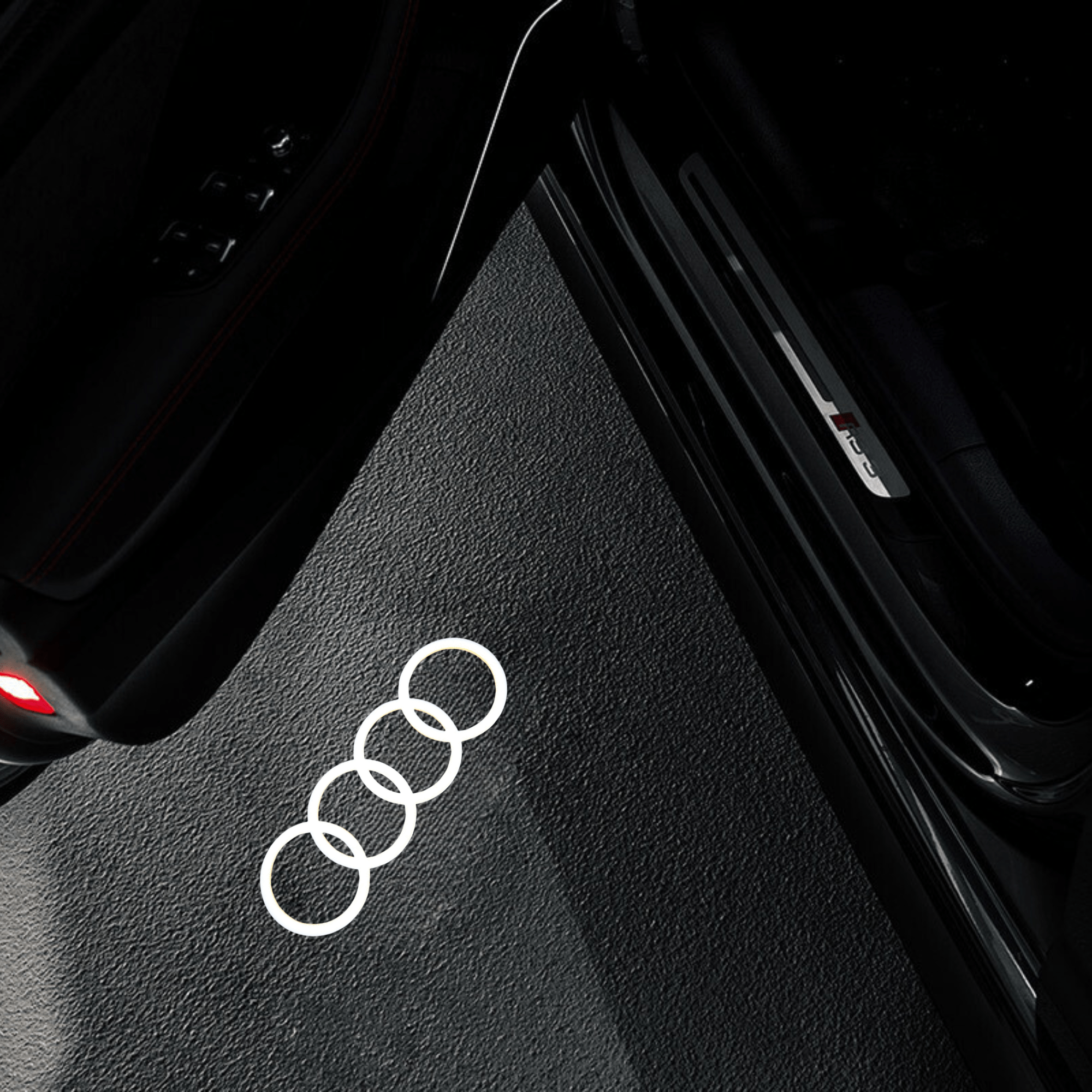 Audi door projector light projecting the Audi rings logo onto the ground, illuminating the entry with a sleek and stylish effect.