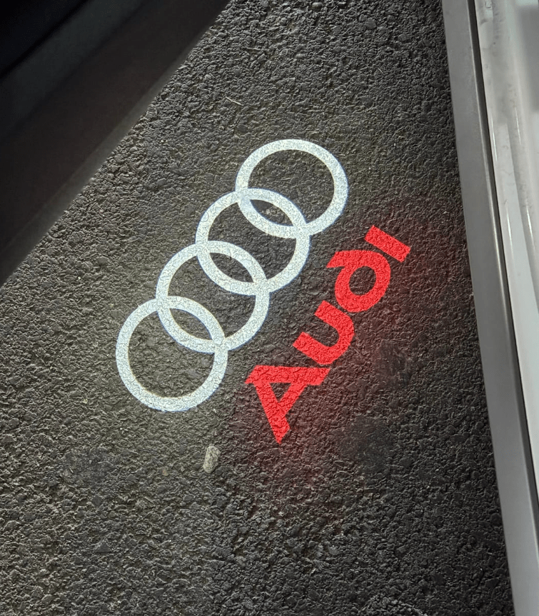 Red Audi LED door projector light illuminating the Audi logo onto the ground, enhancing the premium look of your vehicle.