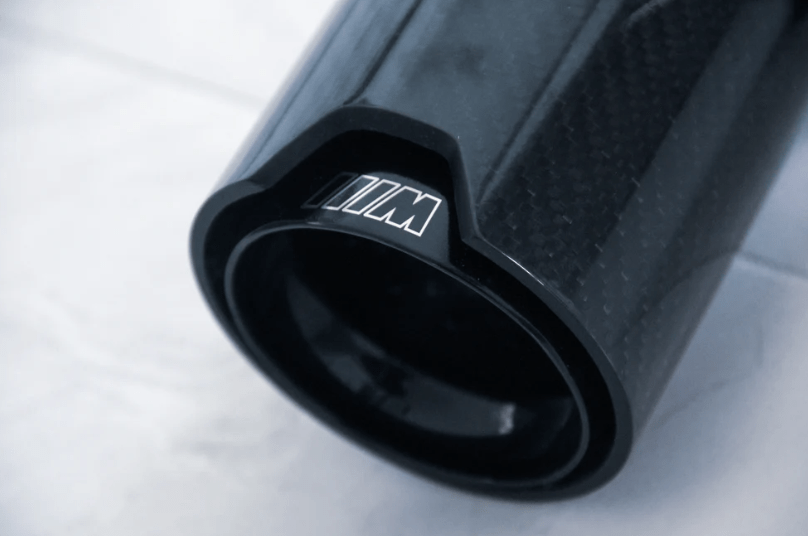 Side view of carbon fiber exhaust tips for BMW M-Series, demonstrating the sleek, aerodynamic design that enhances vehicle performance and aesthetic appeal.