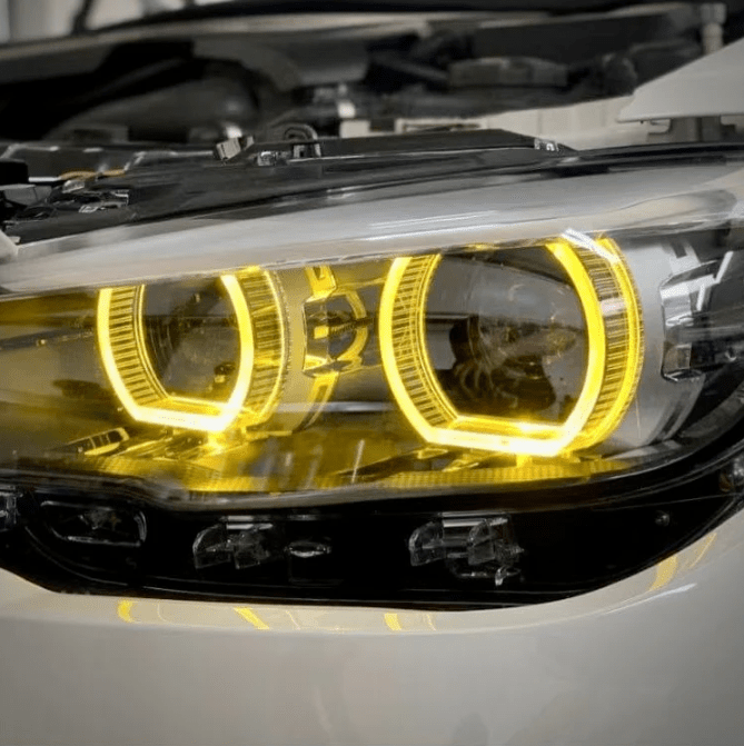 Close-up of BMW F20 CSL yellow DRL module installation for LCI 1 Series, upgrading LED daytime running lights to a high-performance motorsport look