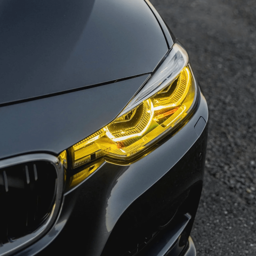 Close-up of BMW F30 CSL yellow DRL module in daylight, showcasing a sporty and aggressive look for 2016-2018 3 Series LCI models.