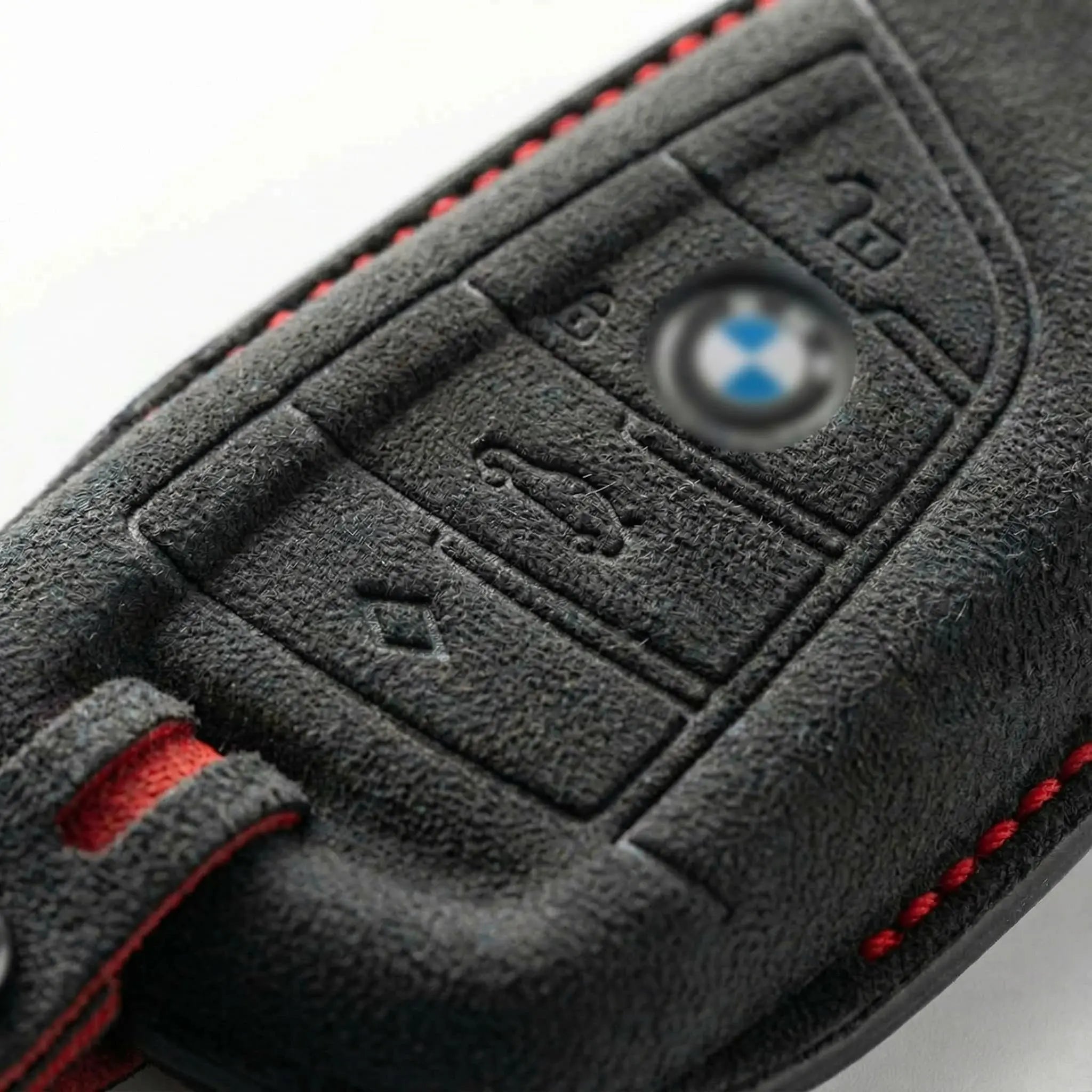 Close-up of a BMW key fob cover with buttons and logo.