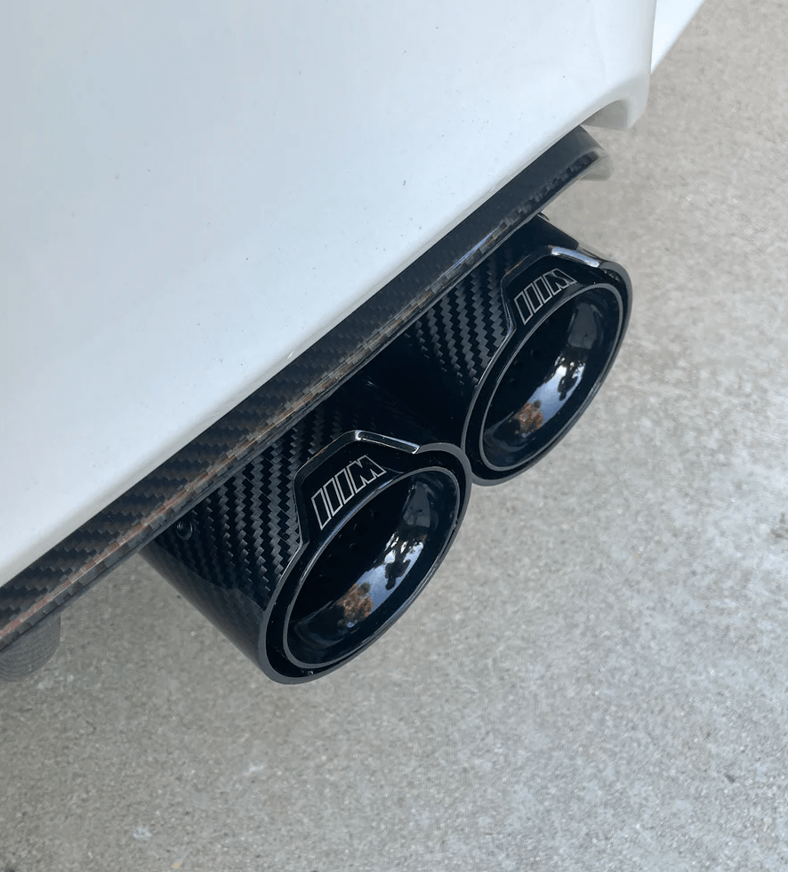 Close-up view of BMW M Performance carbon fiber exhaust tip, emphasizing the premium quality finish and precise craftsmanship for M Series vehicles.